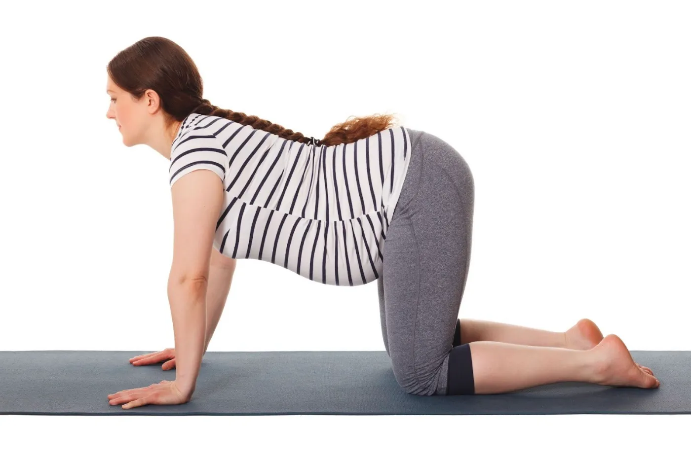 Pregnant woman practicing Cat-Cow yoga pose